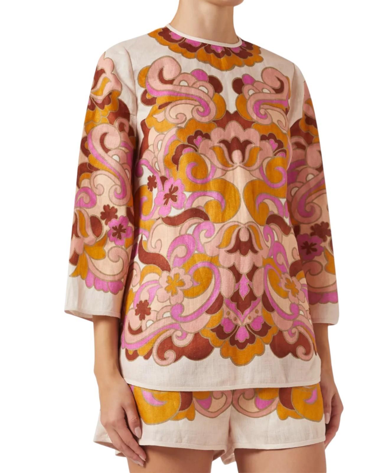 Person wearing a patterned top and shorts on a white background