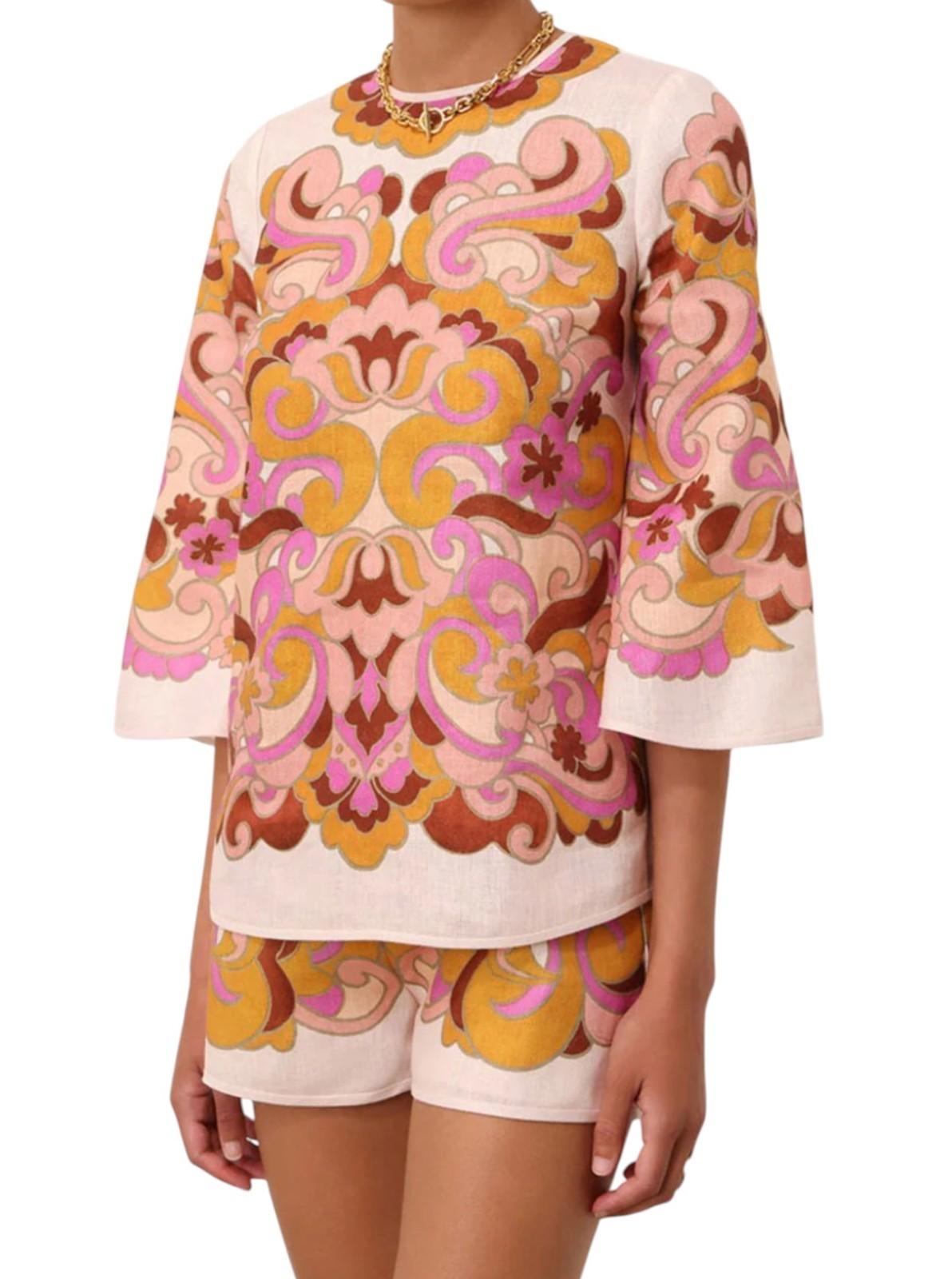 Person wearing a colorful patterned top and shorts on a white background