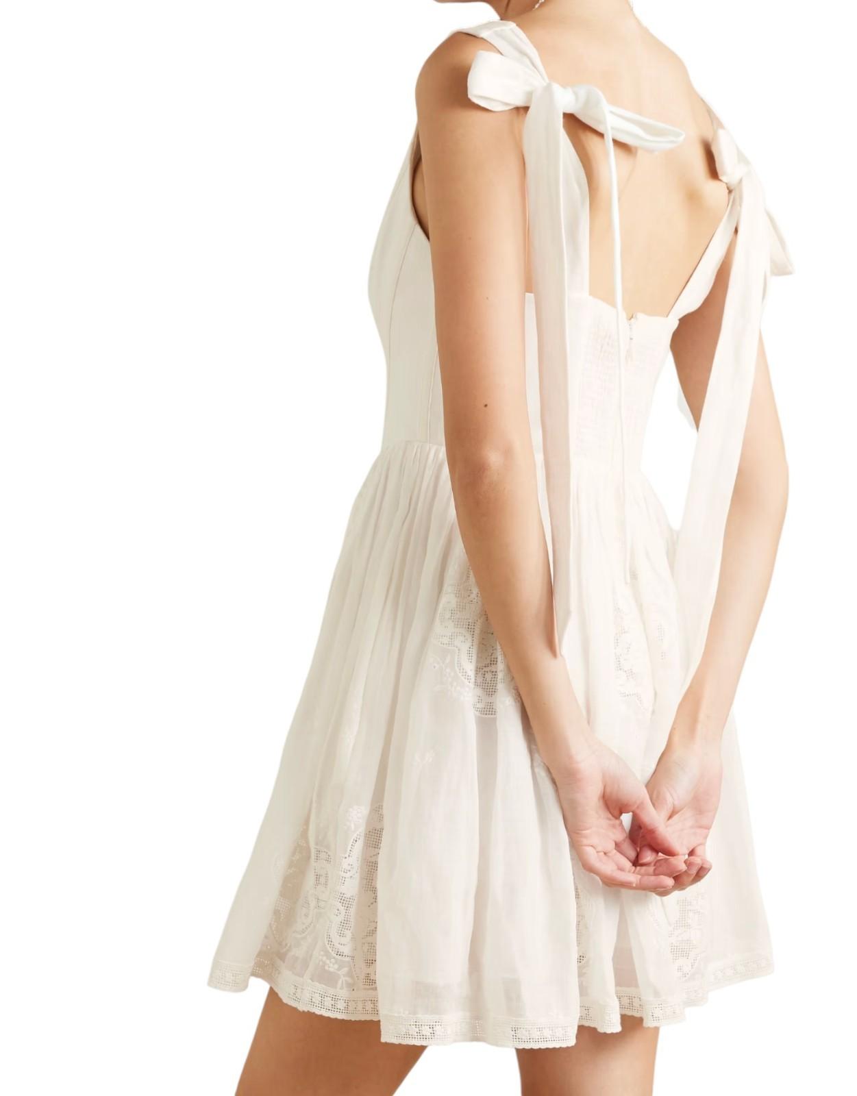 White lace dress with thin straps and a bow detail on a white background