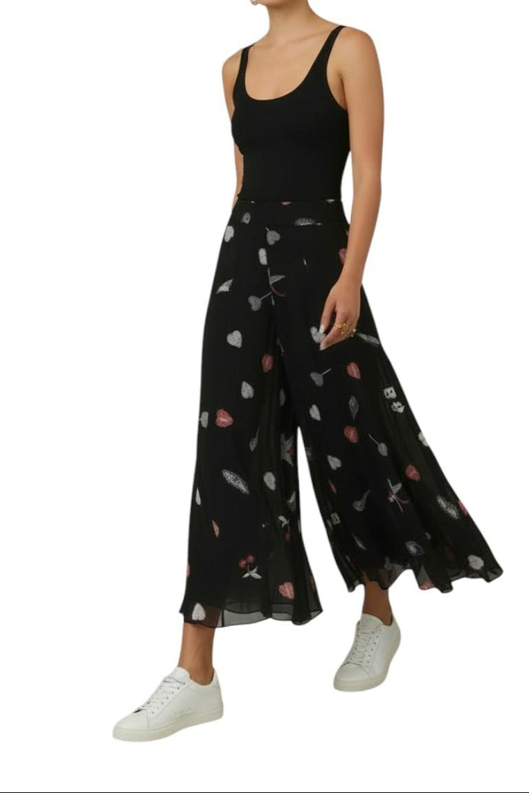 AI-generated image of Person wearing a black sleeveless top and wide-leg pants with heart patterns on a white background
