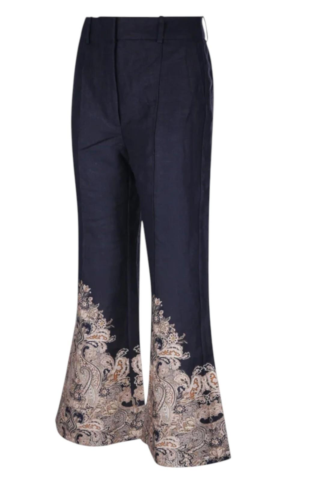 Navy blue pants with intricate white embroidery on a white background
