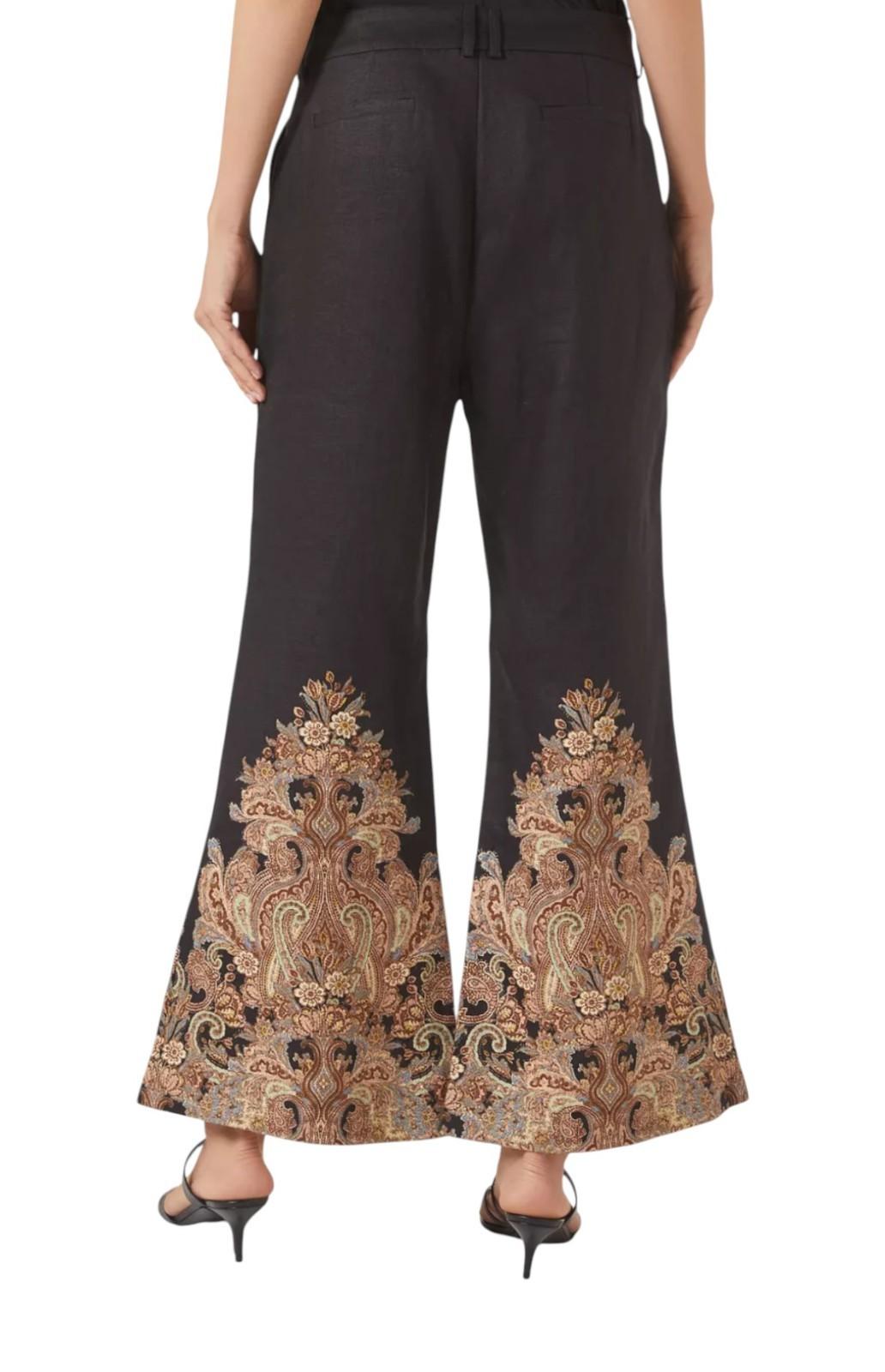 Black pants with intricate gold embroidery on a white background