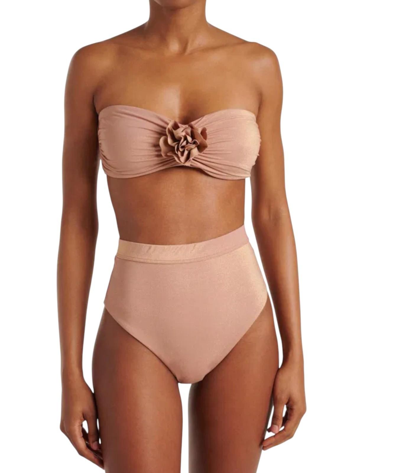 Woman wearing a beige strapless bikini with a floral design on a white background
