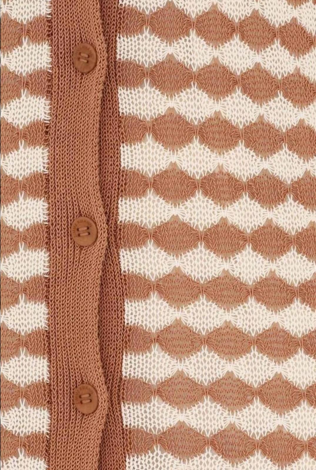 Close-up of a brown and white patterned fabric with buttons.