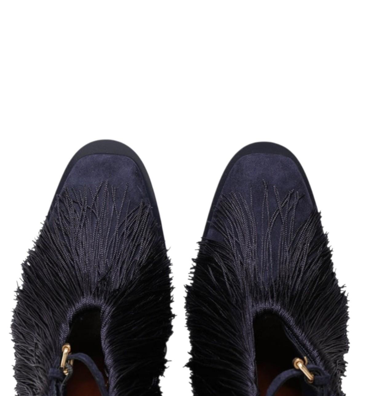 Pair of dark blue fringed shoes on a white background 