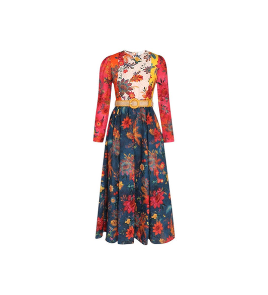A long-sleeved maxi dress with a split floral design, featuring a cream and red floral bodice with a gold belt, and a navy blue floral skirt.