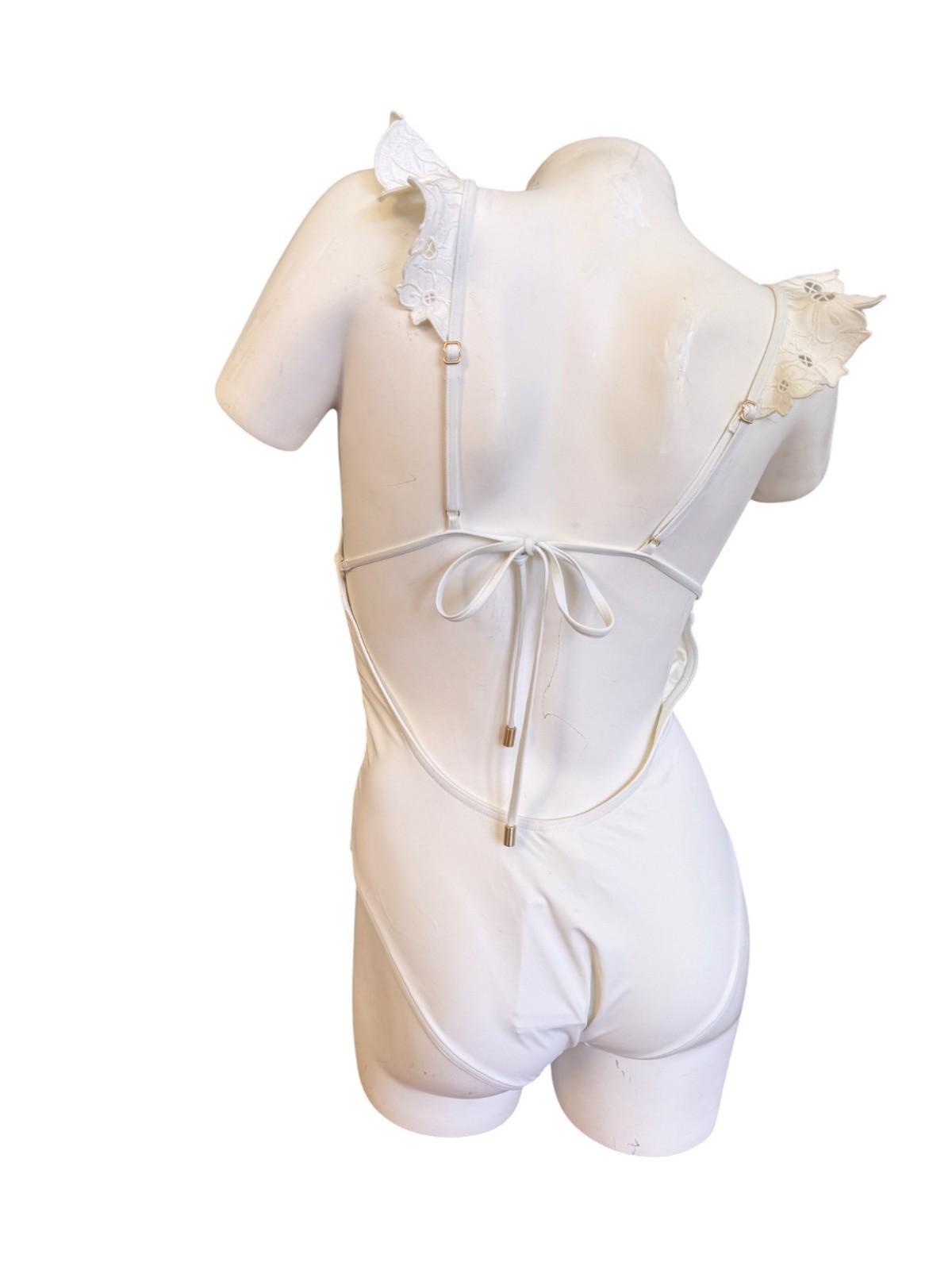 White romper on a mannequin with floral details against a white background