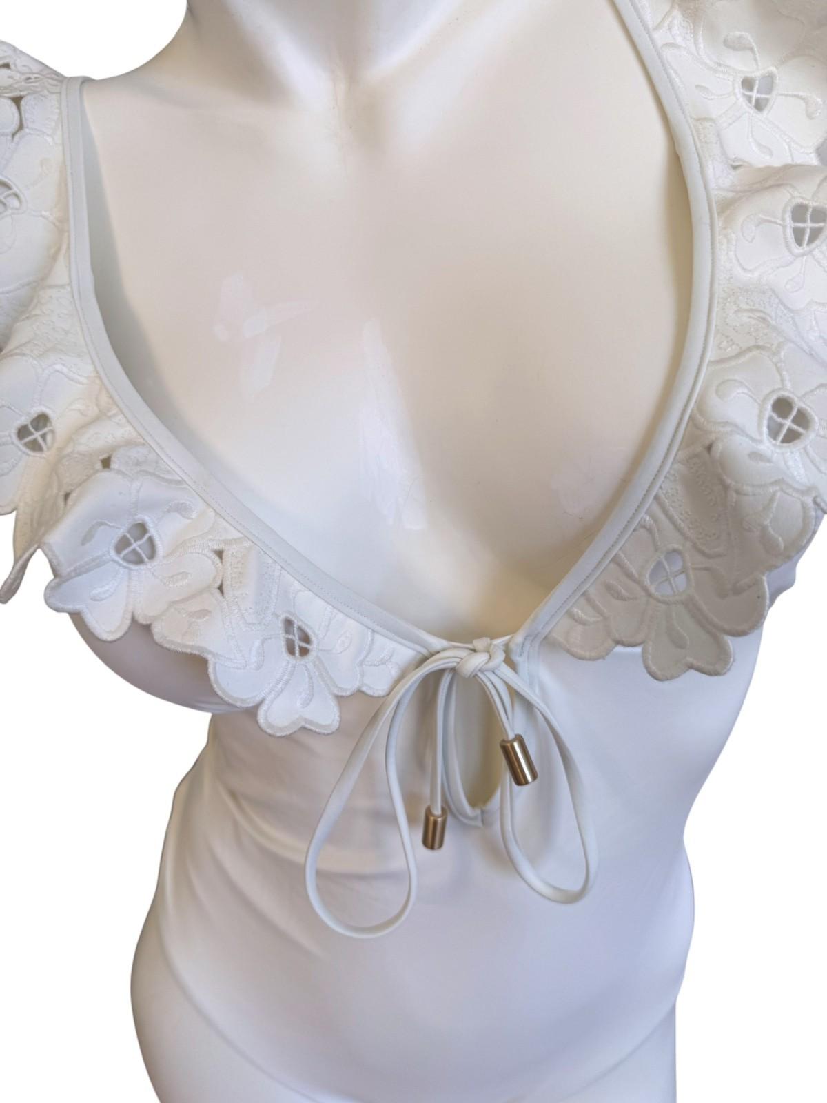 White lace lingerie set on a mannequin with a plain background