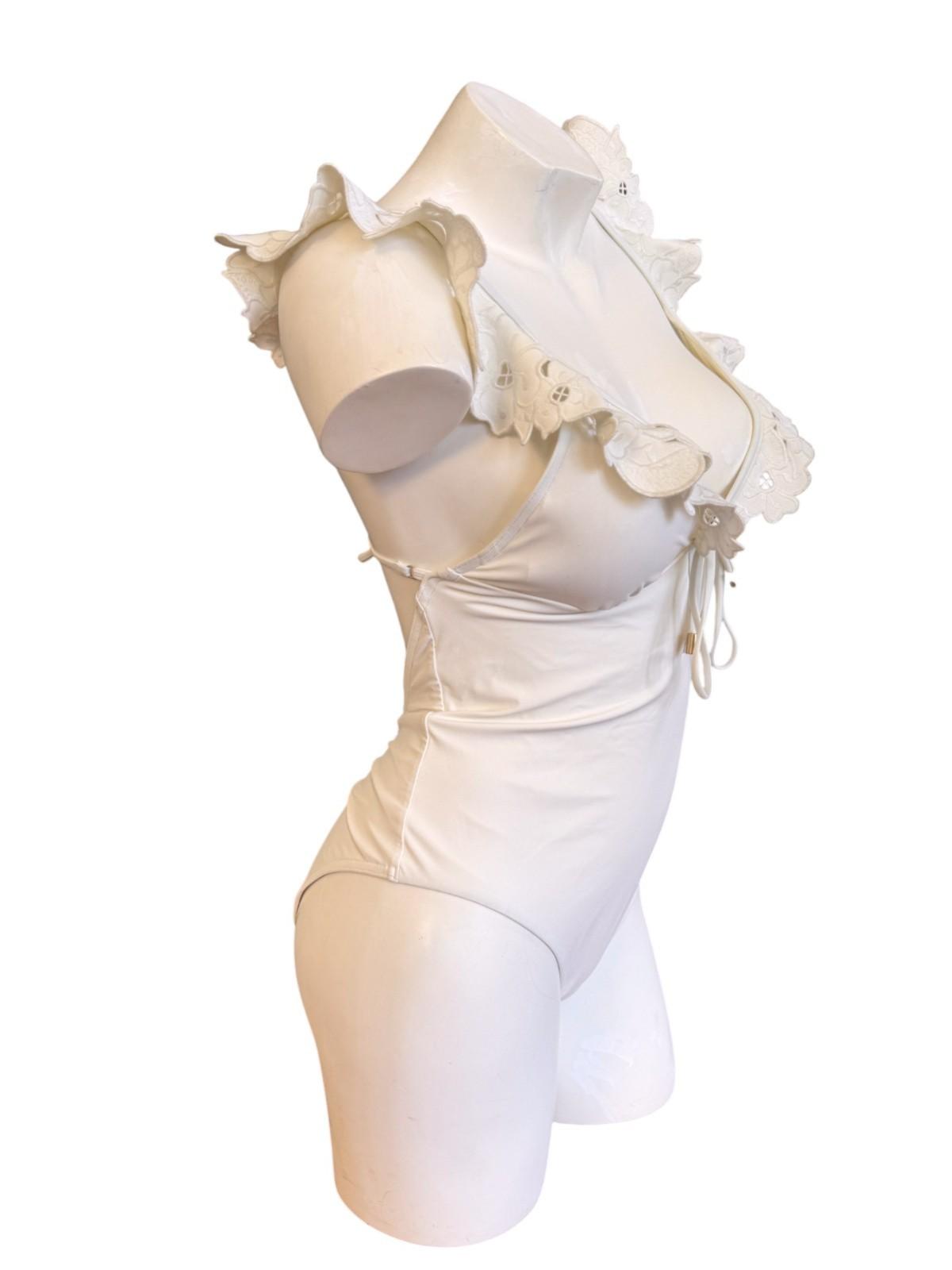 White bodysuit with ruffled shoulders on a mannequin against a white background