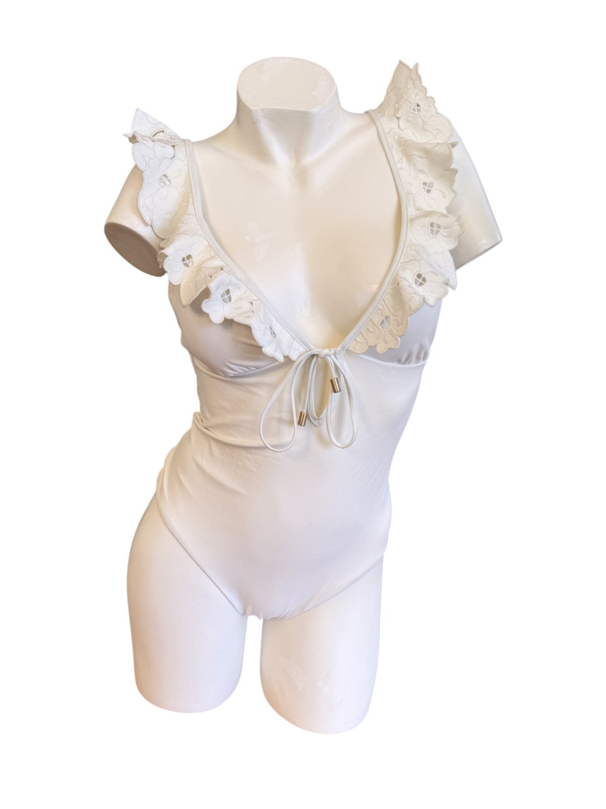 White satin bodysuit with ruffled details on a mannequin against a white background