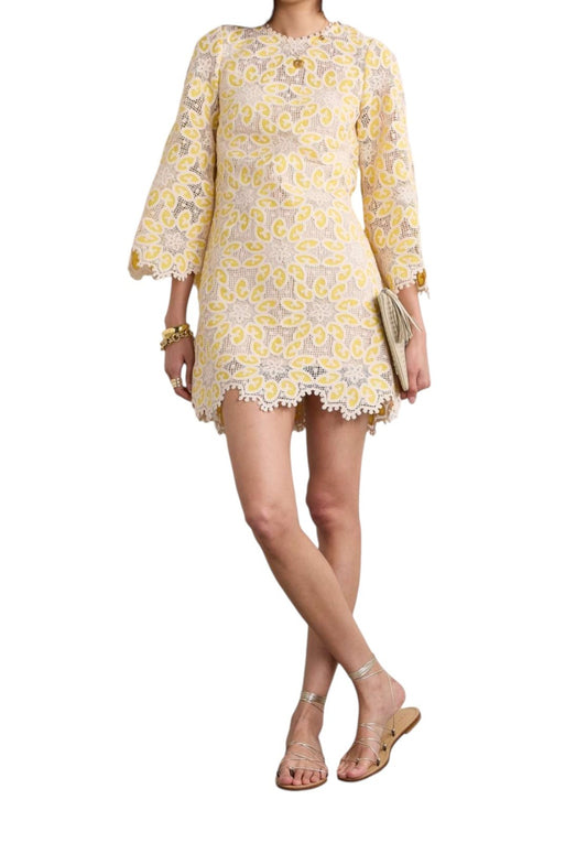 Woman wearing a yellow floral dress on a white background
