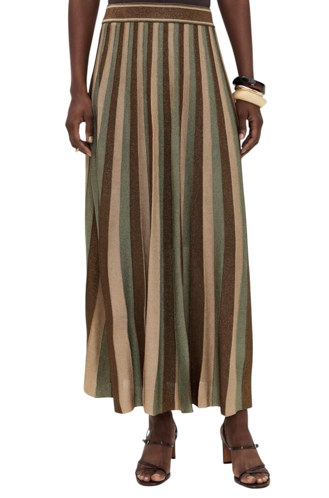 Person wearing a long, striped skirt with earthy tones on a white background