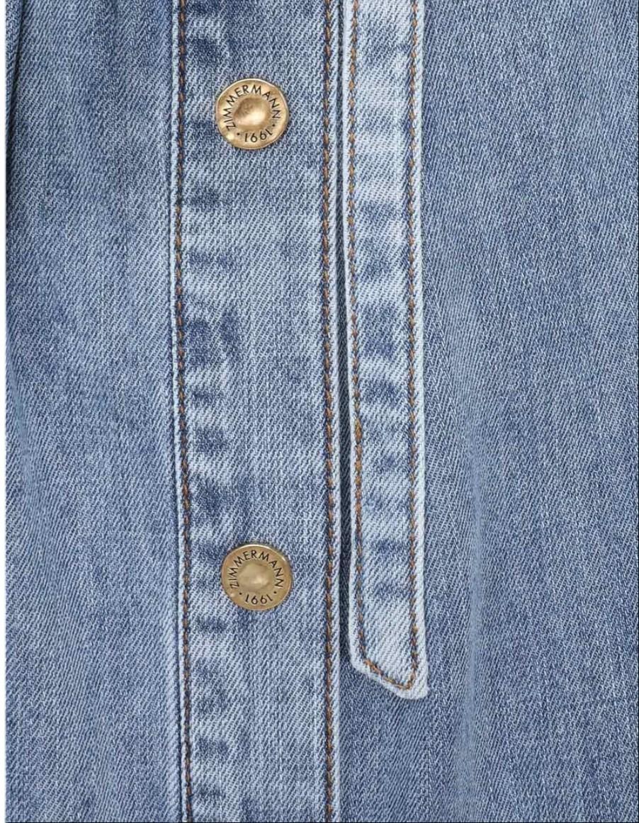 Close-up of a light blue denim jacket with button details