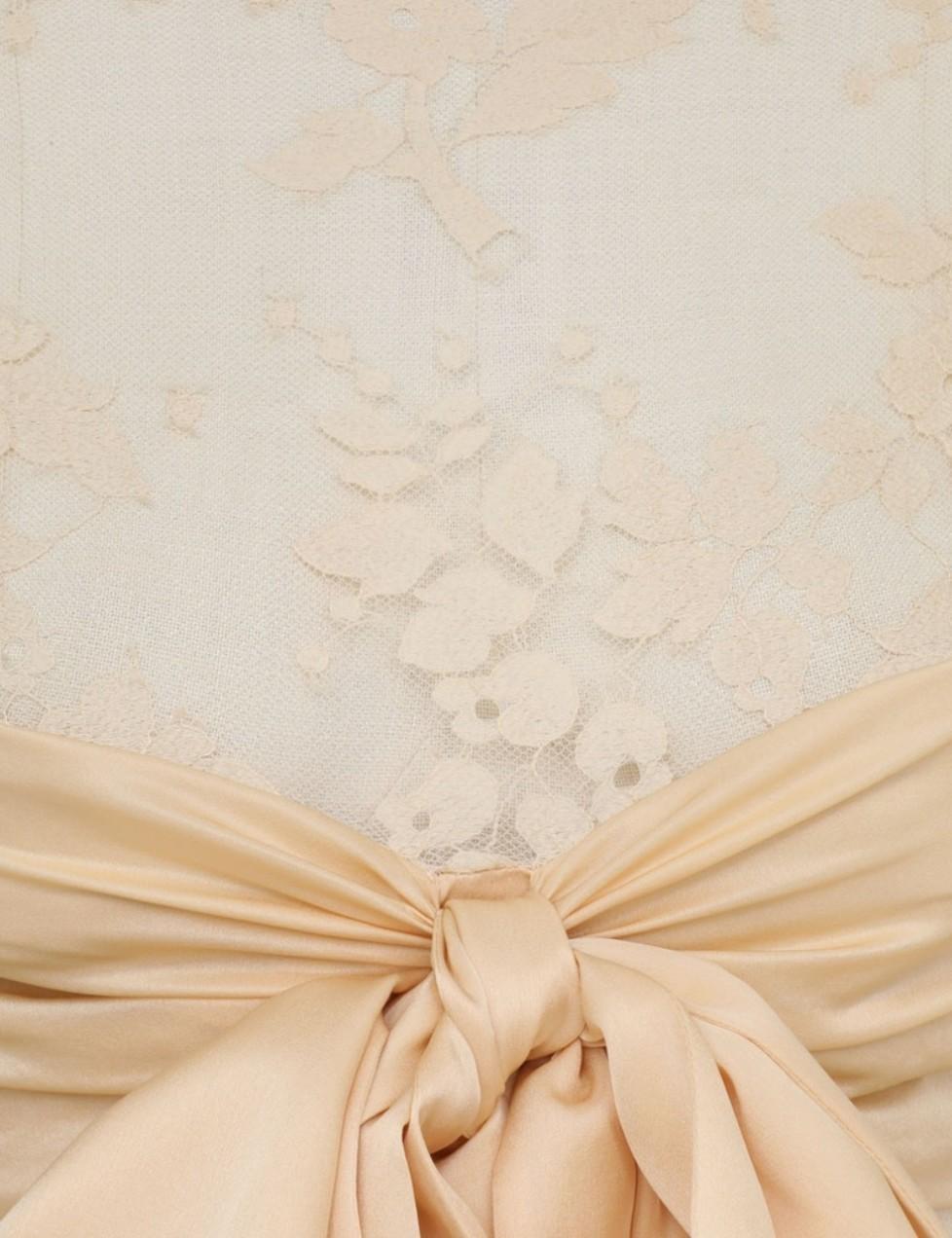 Beige fabric with a large bow on a textured beige background