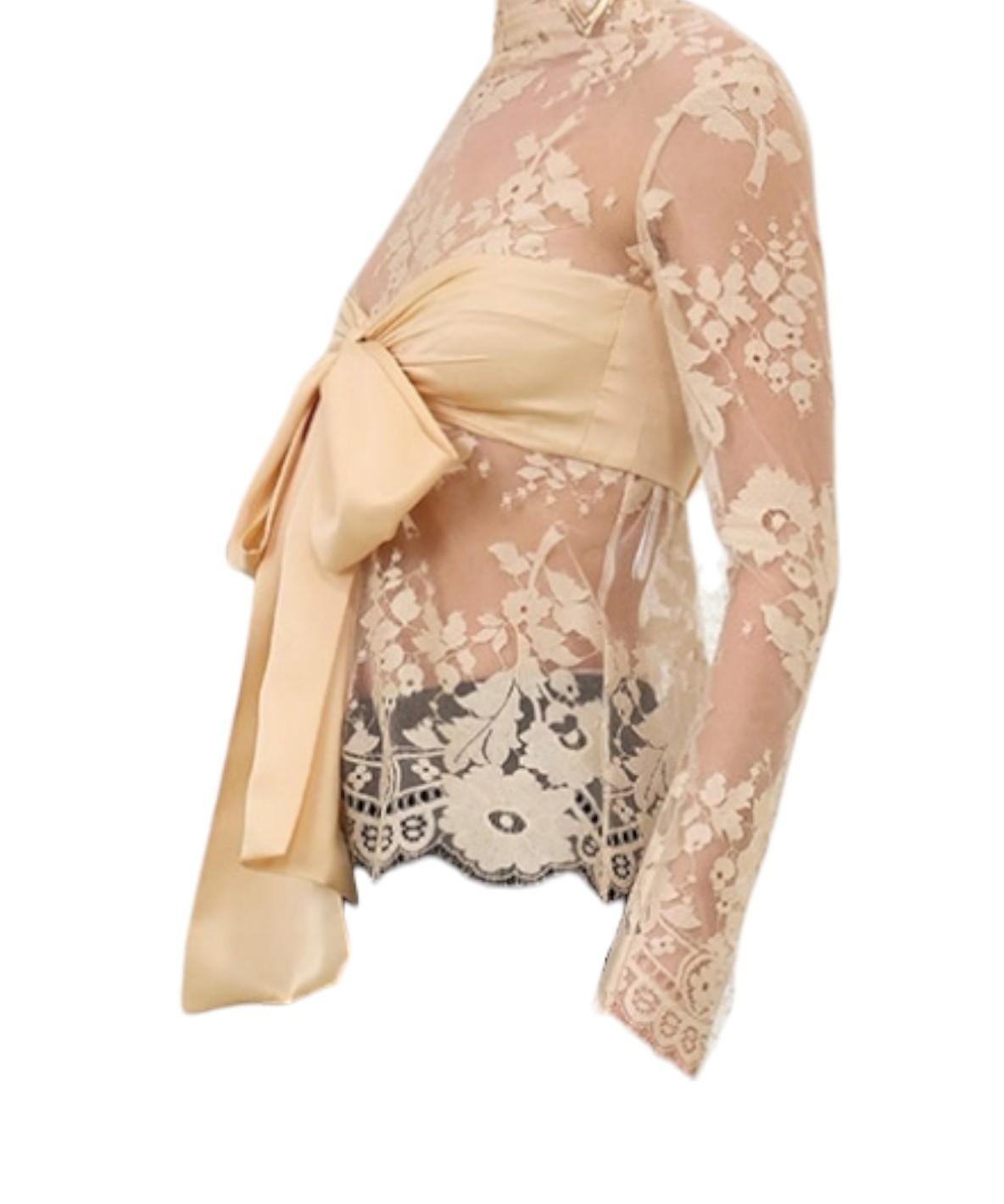 Sheer lace top with a beige bow detail on a white background