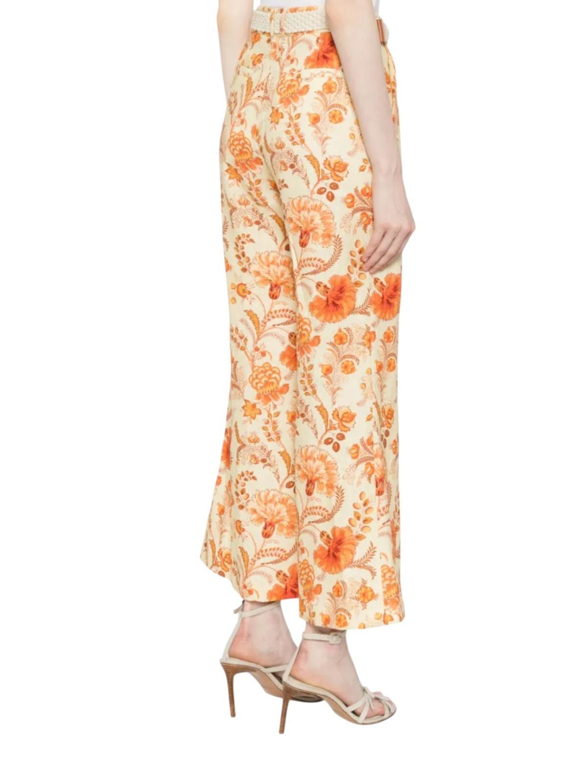 Floral patterned pants worn by a person on a white background
