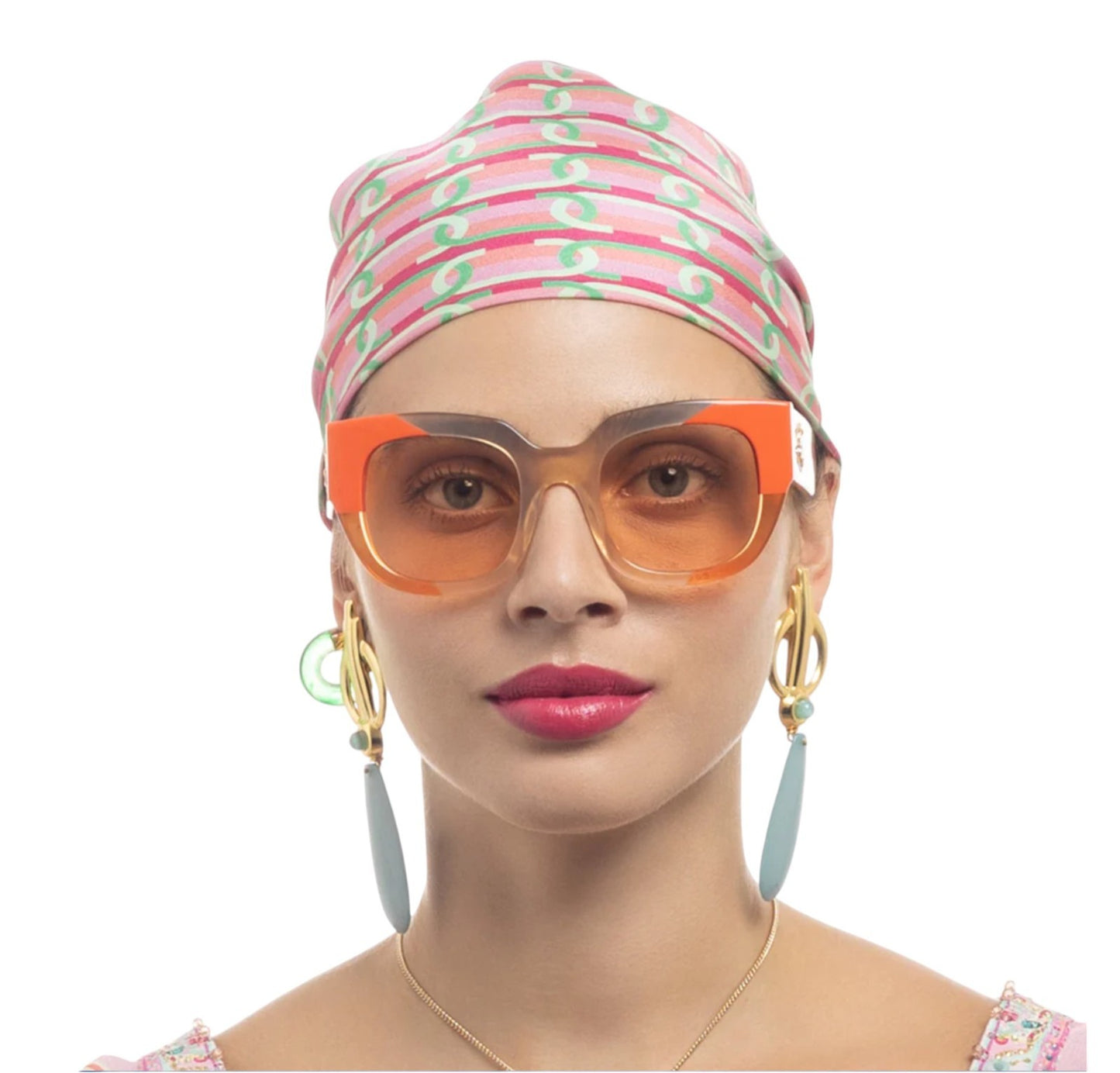 Woman wearing a colorful headscarf and orange sunglasses on a white background