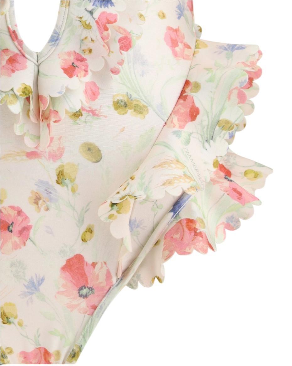 Floral-patterned baby romper with ruffled details on a white background