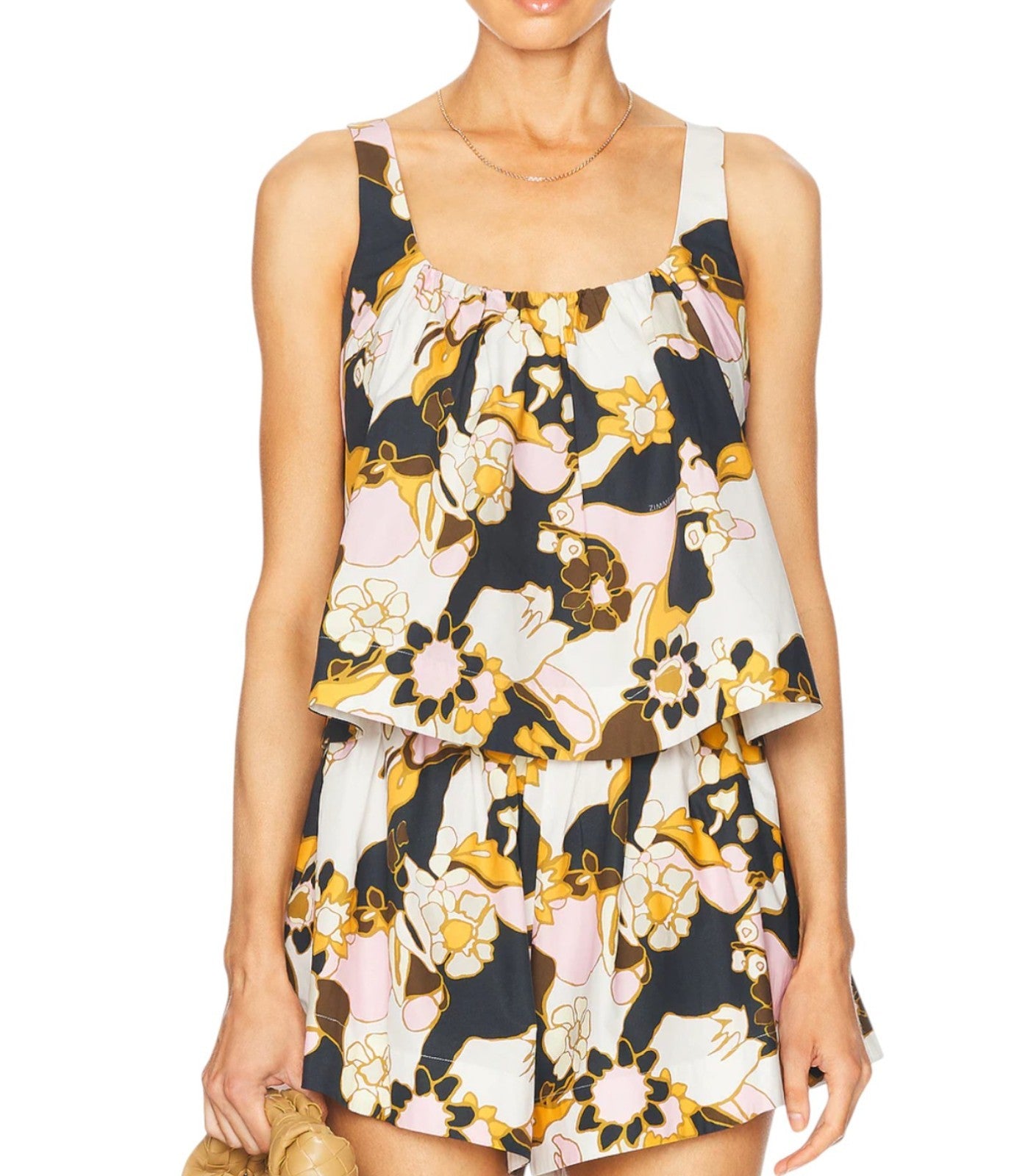 Woman wearing a sleeveless dress with a floral pattern on a white background