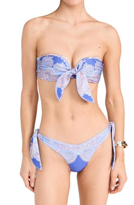 Woman wearing a blue and white patterned bikini on a white background