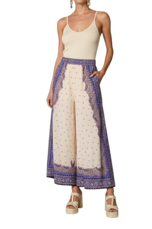 AI generated image of Woman wearing a cream sleeveless top and a long, patterned skirt on a white background