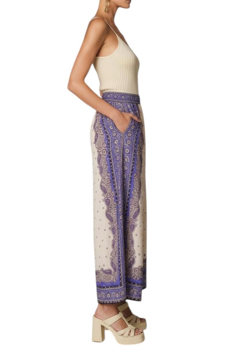 AI generated image of Woman wearing a cream top and patterned pants on a white background