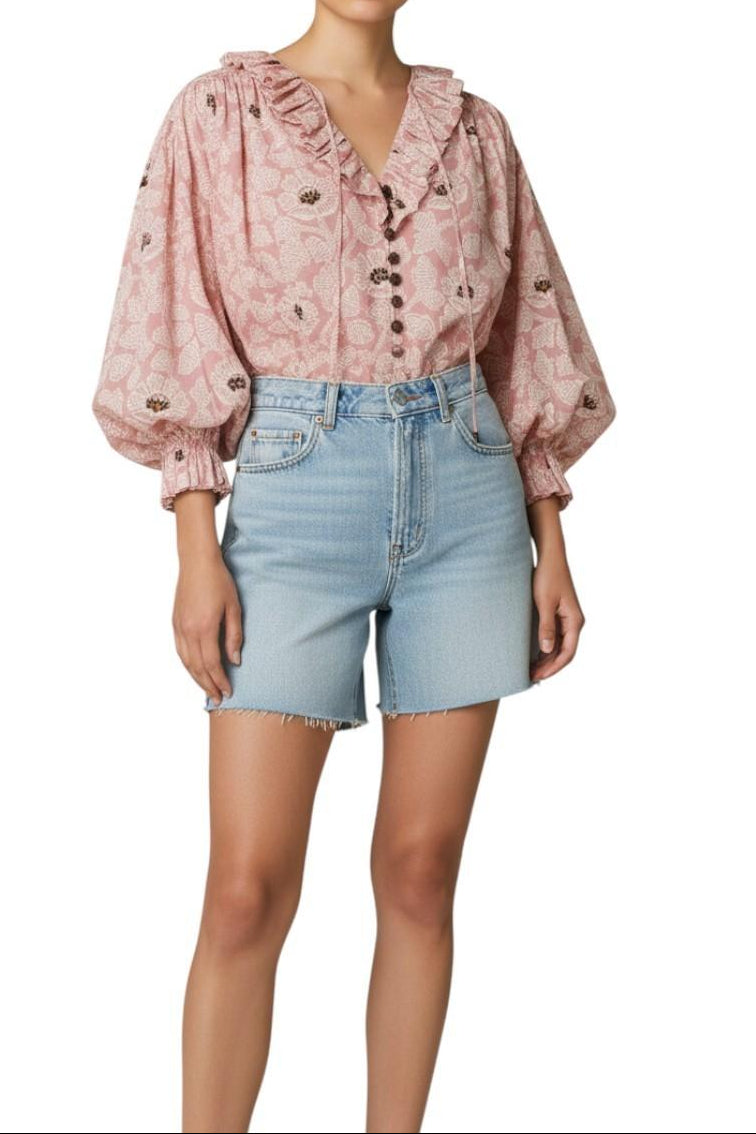 AI-generated image of Person wearing a pink floral blouse and light blue denim shorts on a white background