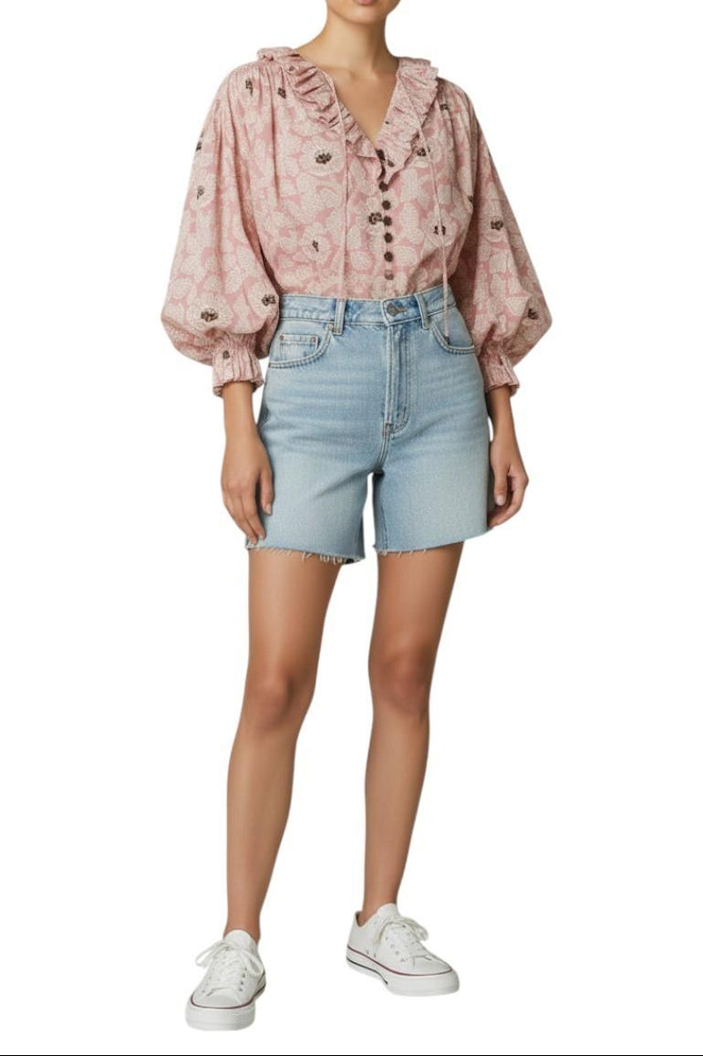 AI-generated image of Woman wearing a pink blouse with ruffled details and light blue denim shorts on a white background