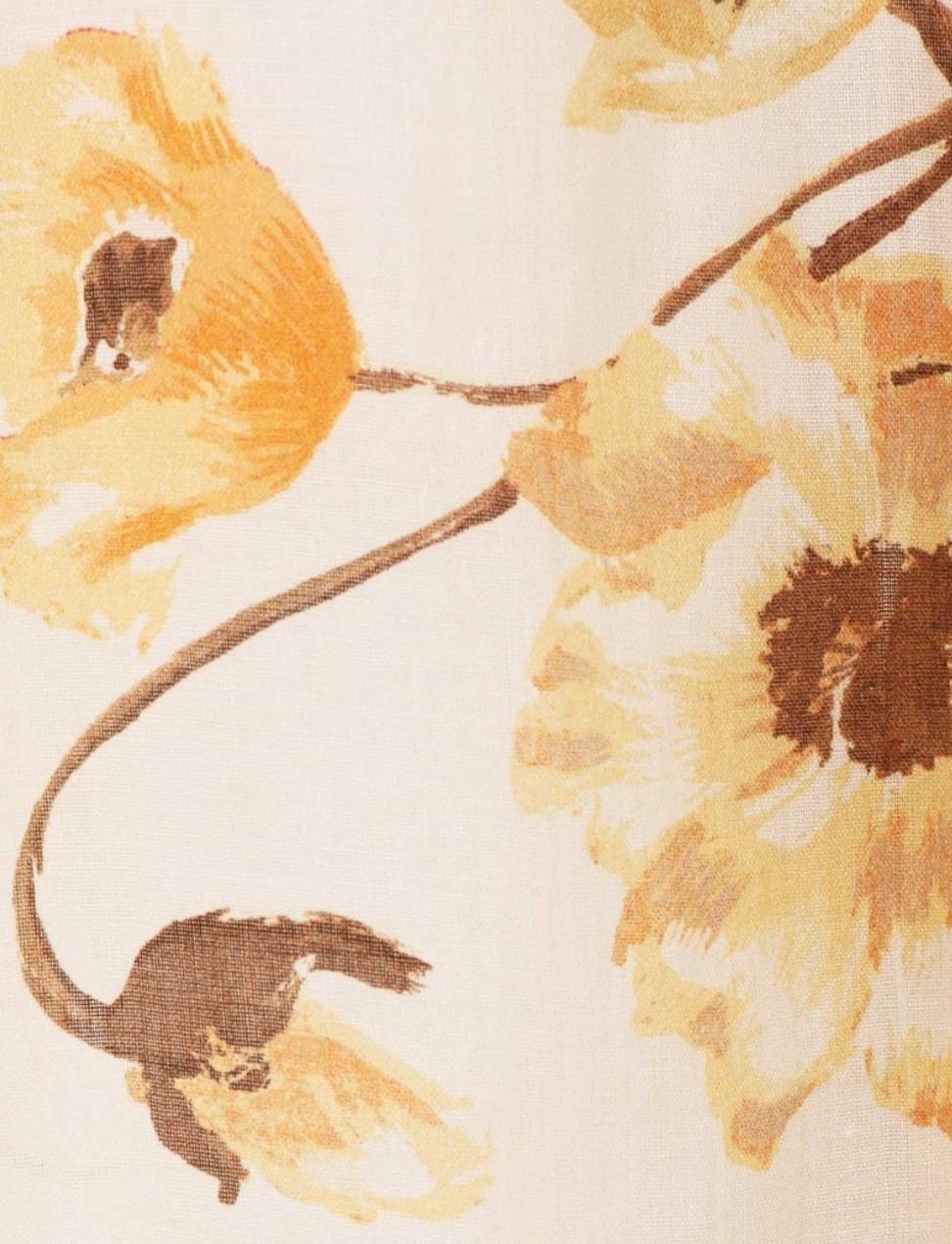 Close-up of a floral pattern with yellow flowers and brown leaves on a beige background