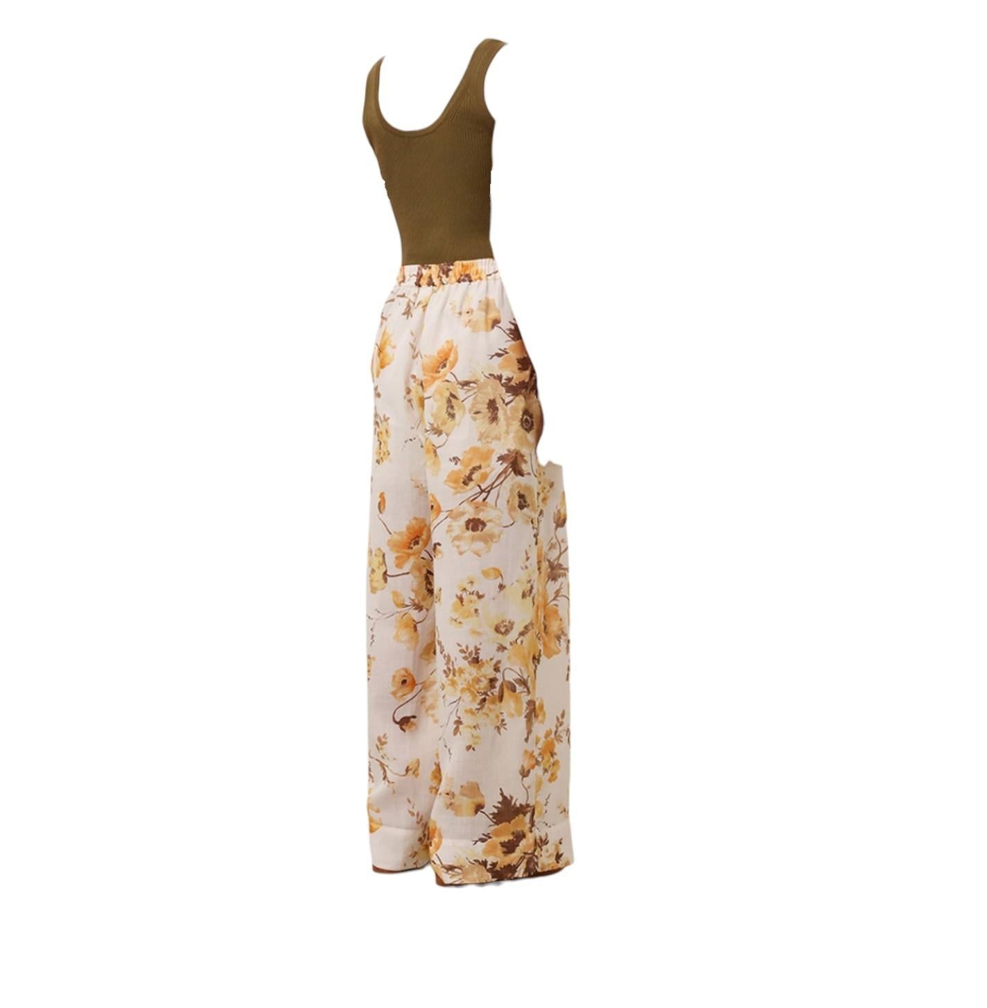 Floral wide-leg pants with a green tank top on a white background