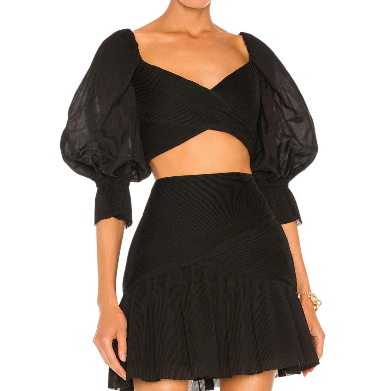 Black crop top with puffed sleeves and a black skirt on a white background