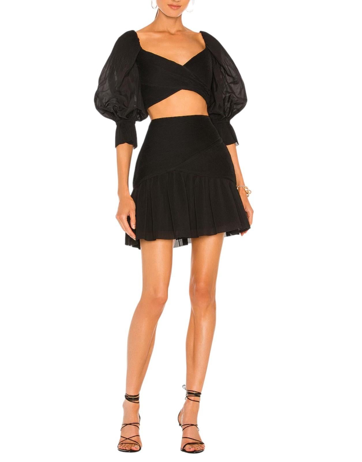 Woman wearing a black outfit with puffed sleeves and a skirt on a white background