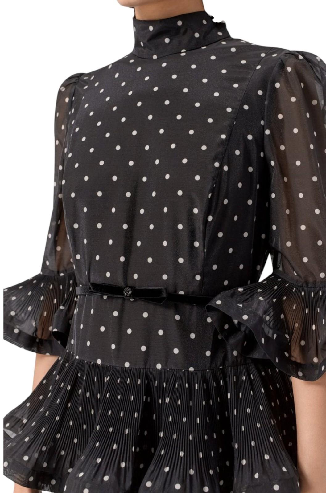 Black polka dot dress with sheer sleeves on a white background