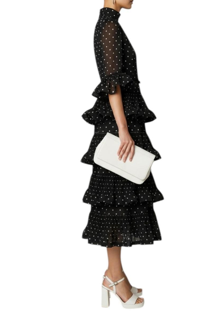 AI generated image of Woman wearing a black ruffled dress with white polka dots, holding a white clutch.