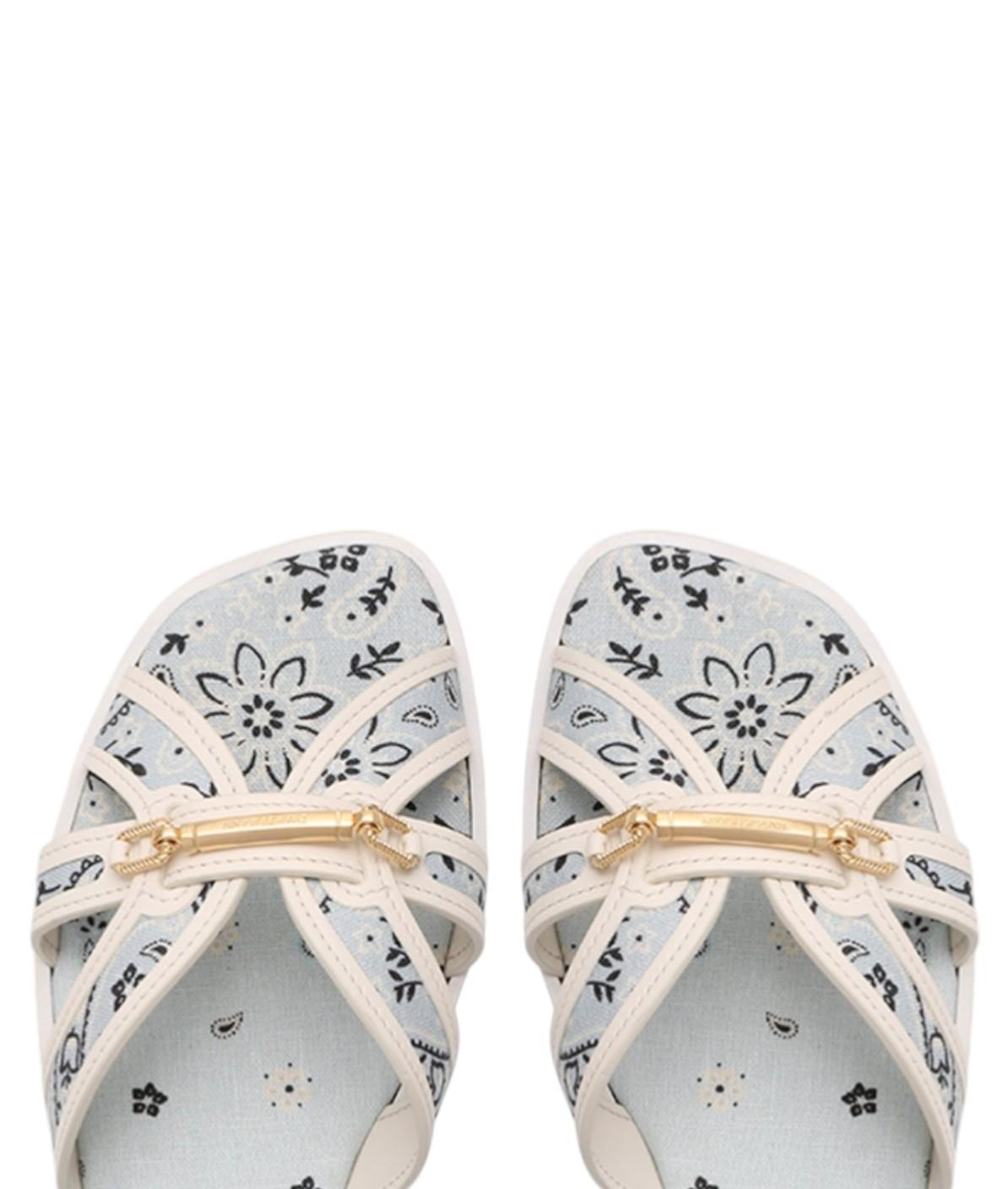 Pair of floral-patterned sandals with a gold buckle on a white background
