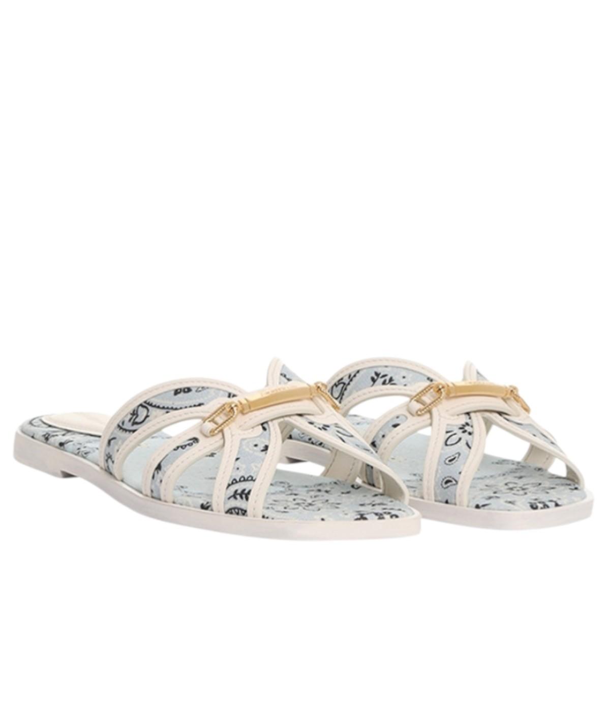 Pair of white sandals with floral patterns on a white background