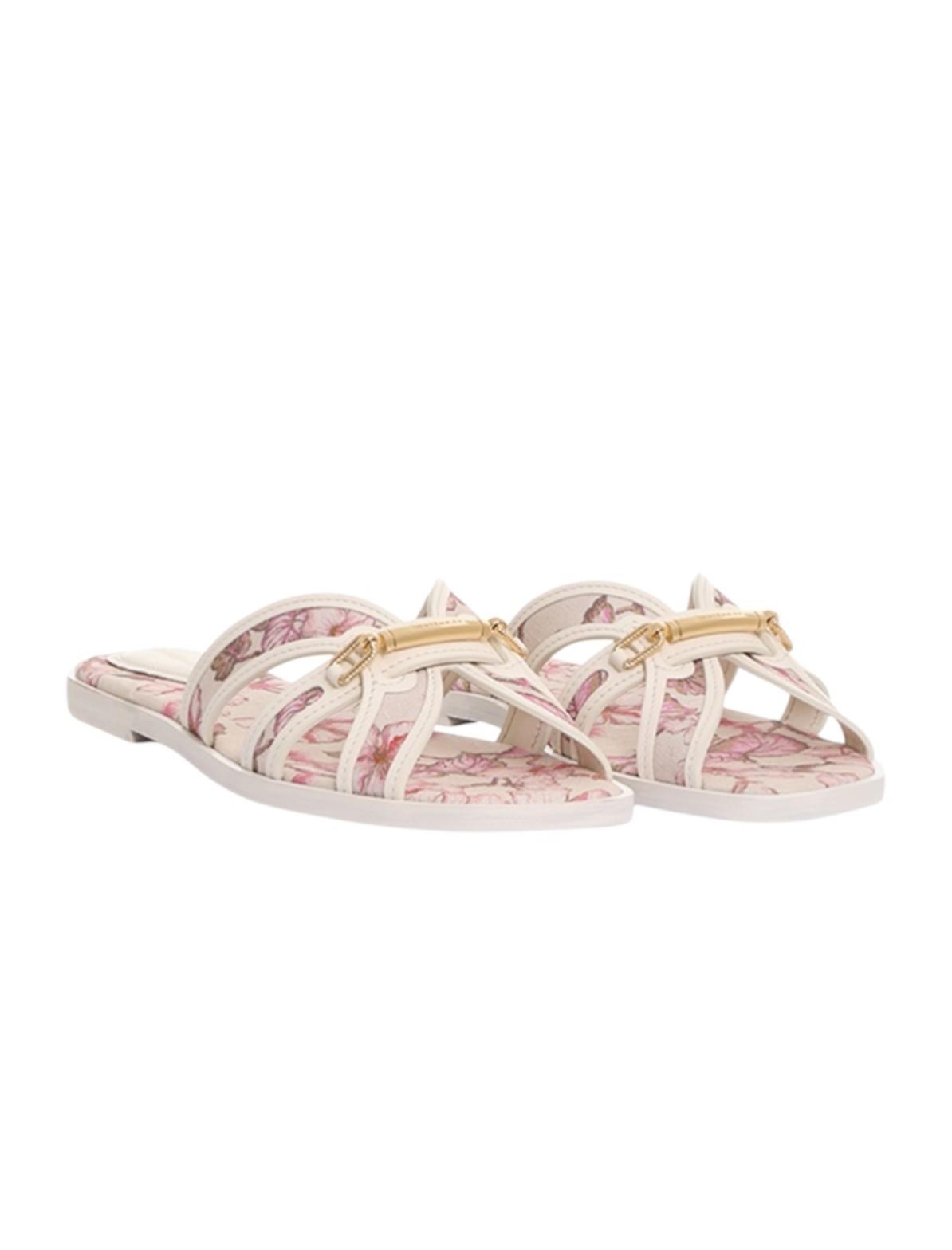 Pair of white sandals with floral pattern and gold accents on a white background