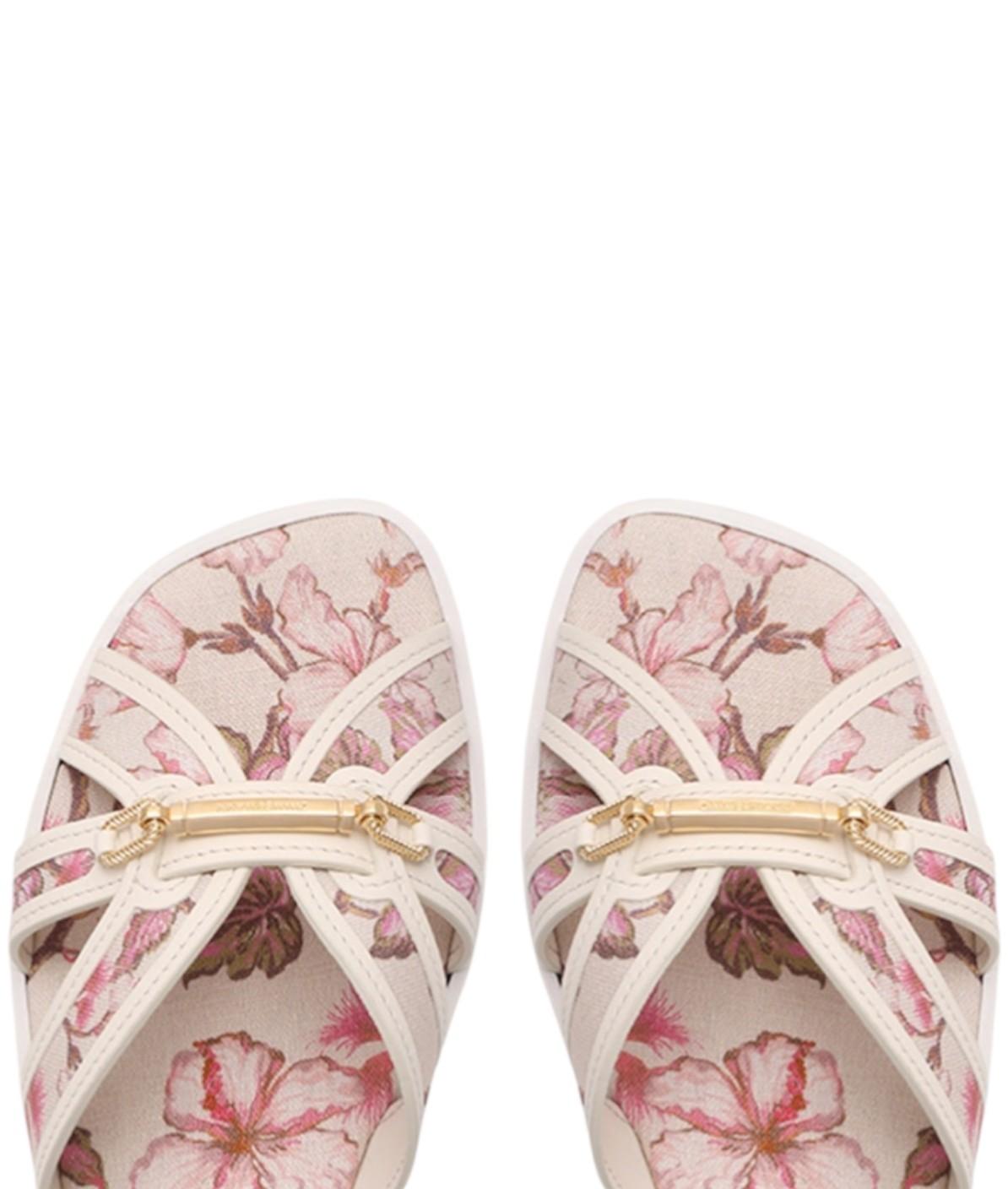 Pair of floral sandals with a gold strap on a white background