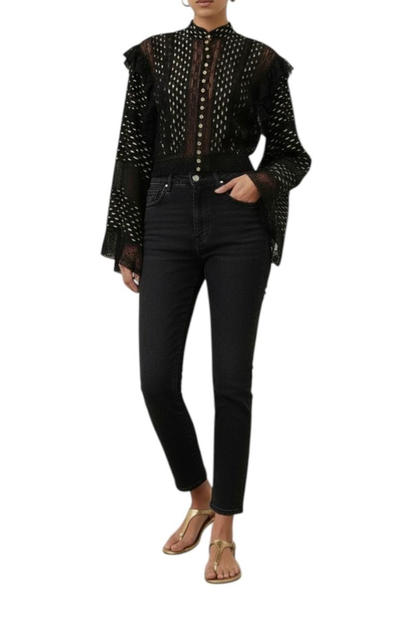 Person wearing a black patterned blouse with sheer sleeves and black jeans on a white background