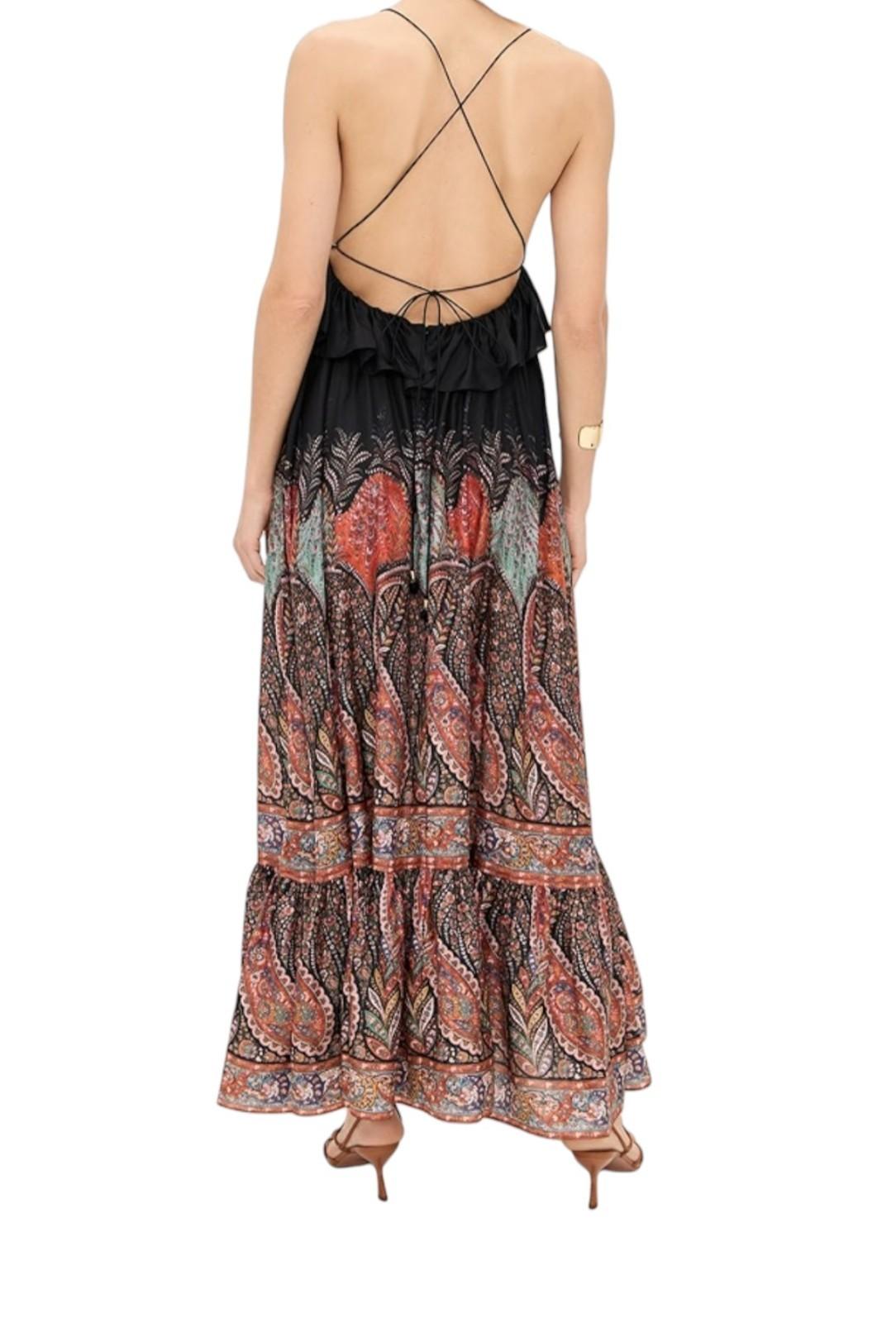 Woman wearing a patterned dress with a backless design on a white background
