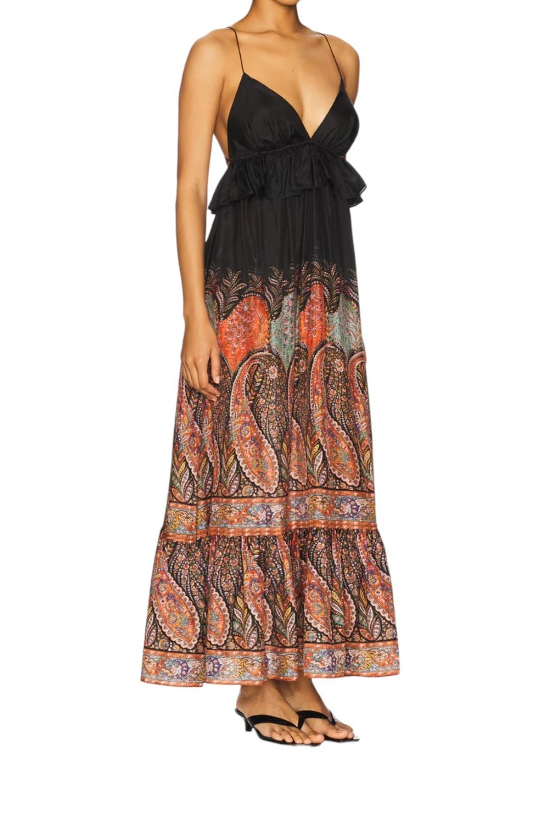 Woman wearing a black and patterned long dress on a white background