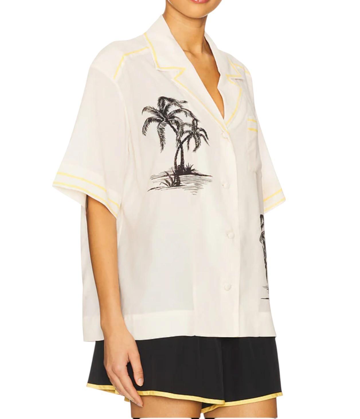 White shirt with palm tree design and black shorts on a white background