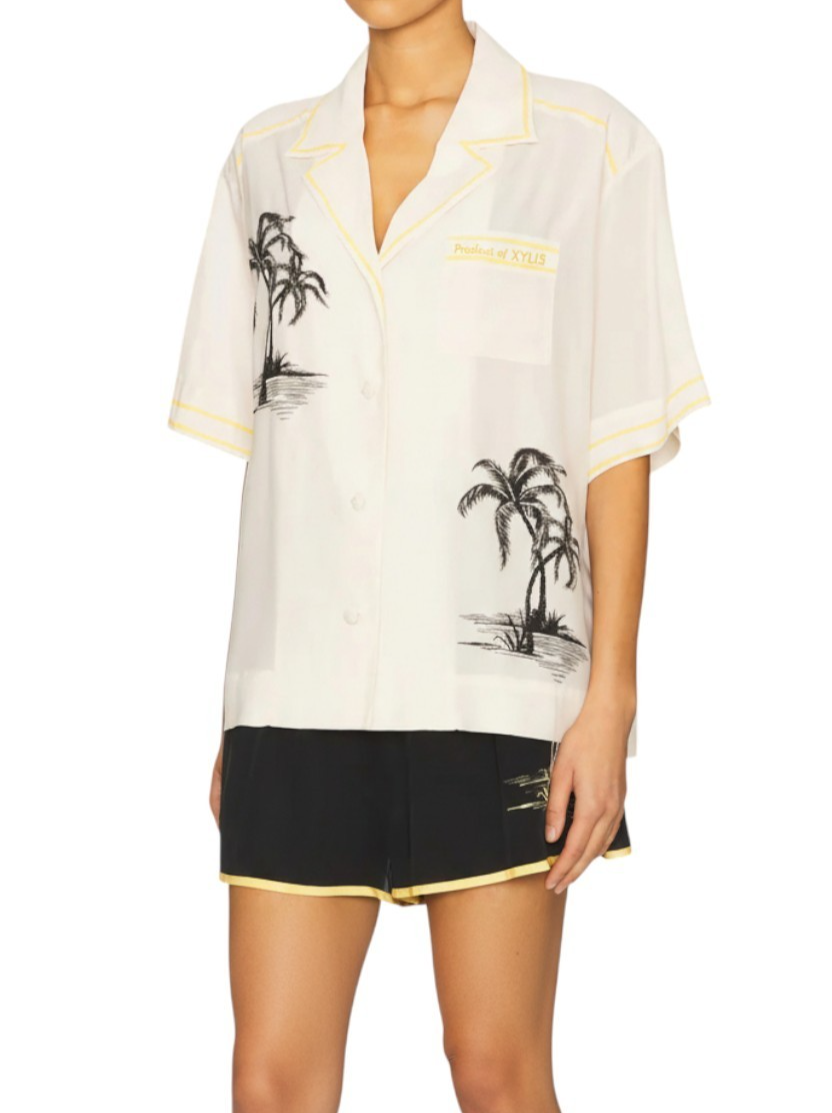 White shirt with palm tree design and black shorts on a white background