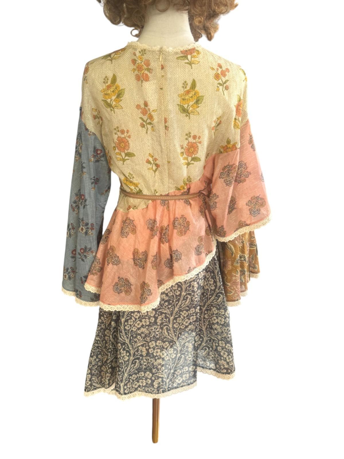 Mannequin wearing a layered outfit with floral and paisley patterns on a white background