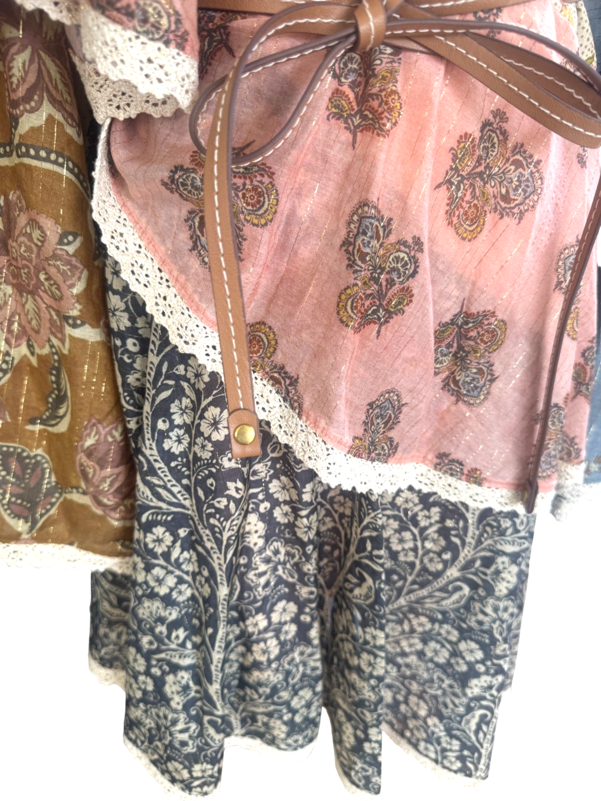 Close-up of a patterned fabric with lace trim and a brown ribbon.