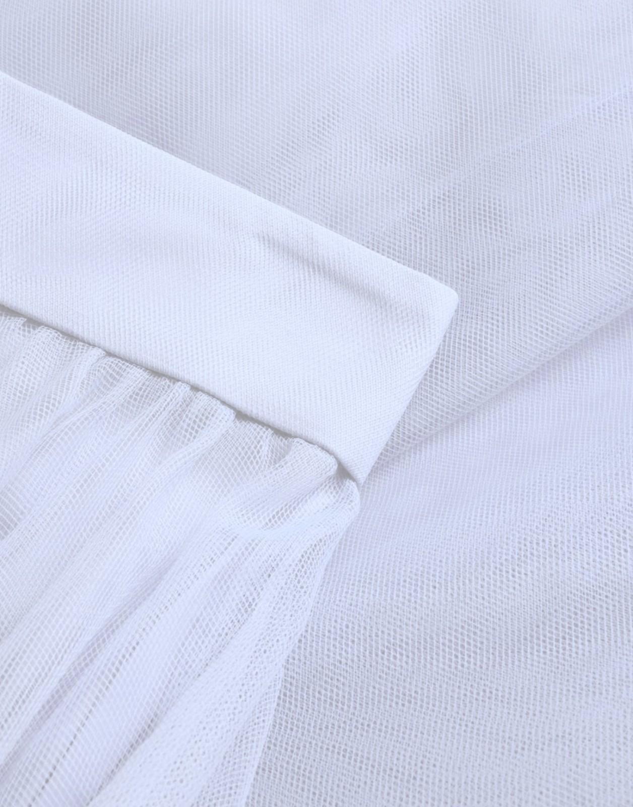 Close-up of white fabric with a textured pattern on a light gray background