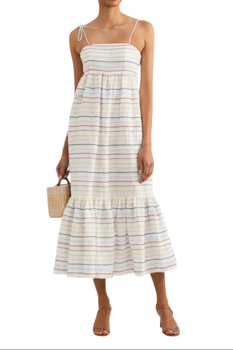 AI generated image of Woman wearing a striped dress holding a woven bag on a white background