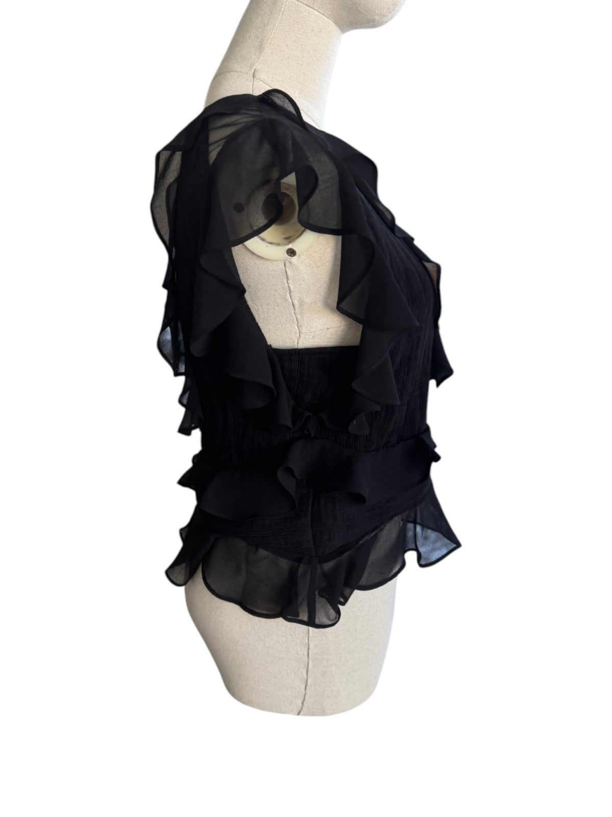 Naked Pear Shakuhachi black pleated mesh top with feminine ruffles and frills on a mannequin, side view.