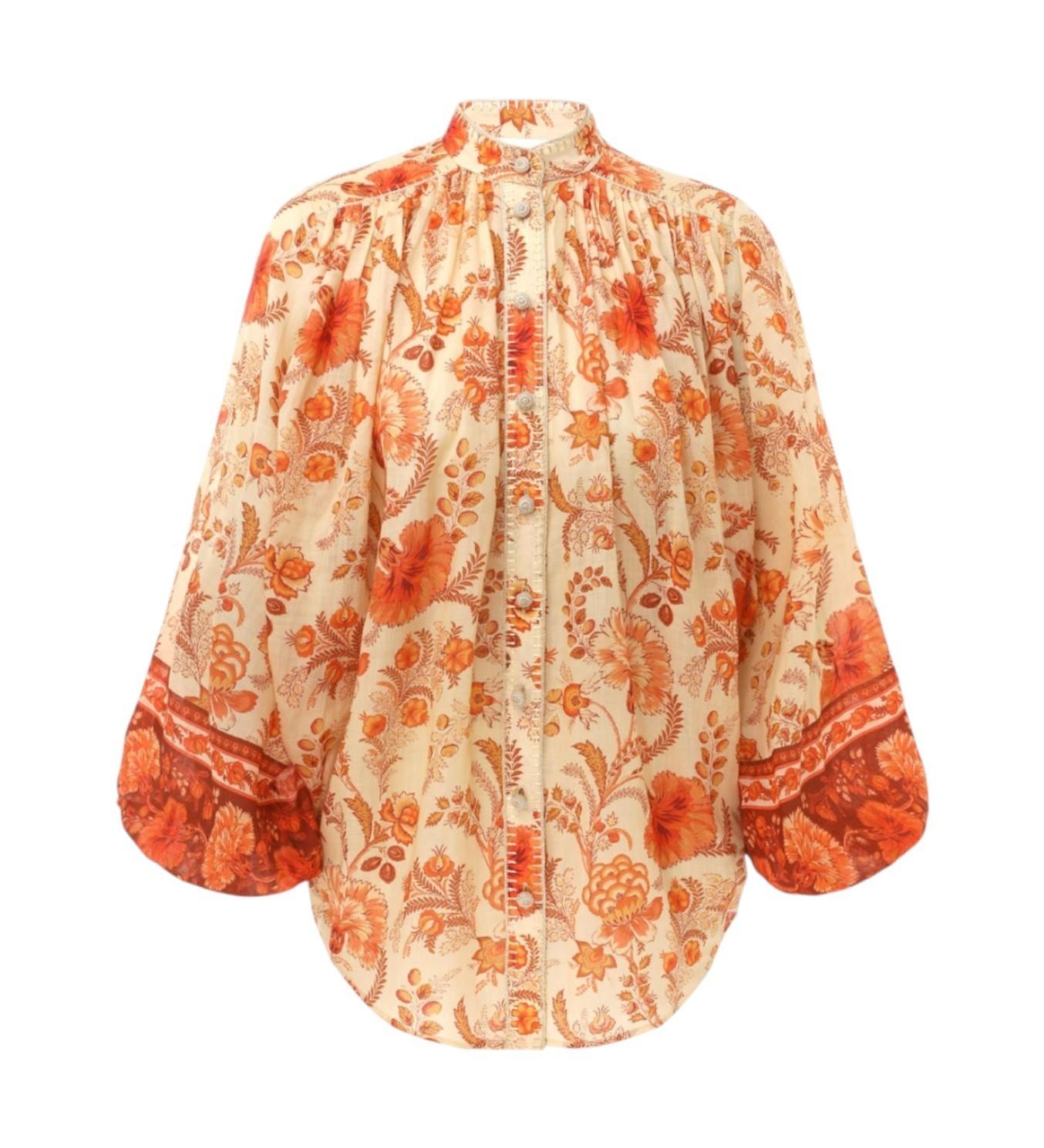 Floral patterned blouse with orange and beige colors on a white background